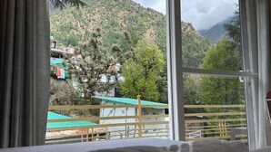 A room with a large window overlooking a mountainous landscape.