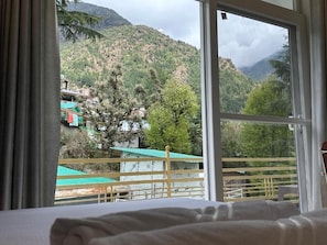 A room with a large window overlooking a mountainous landscape.