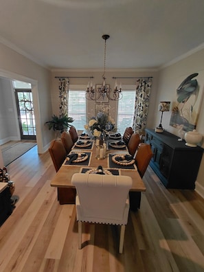 Comedor con mesa de madera dispuesta para seis personas, rodeada de sillas.