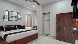 Ein Schlafzimmer mit Bett, Kleiderschrank, Dusche und Deckenventilator.