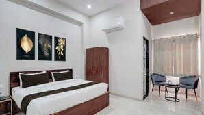 Ein modernes Schlafzimmer mit einem hölzernen Bett, einem Kleiderschrank, einem kleinen Tisch mit Stühlen und Bildern an der Wand.