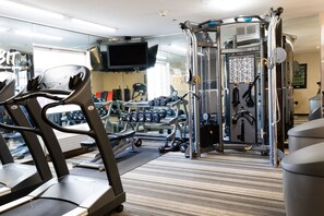 A gym with treadmills, weight machines, and a mirrored wall. - Coratel Suites Extended Stay MSP Airport Minneapolis Richfield (Richfield)