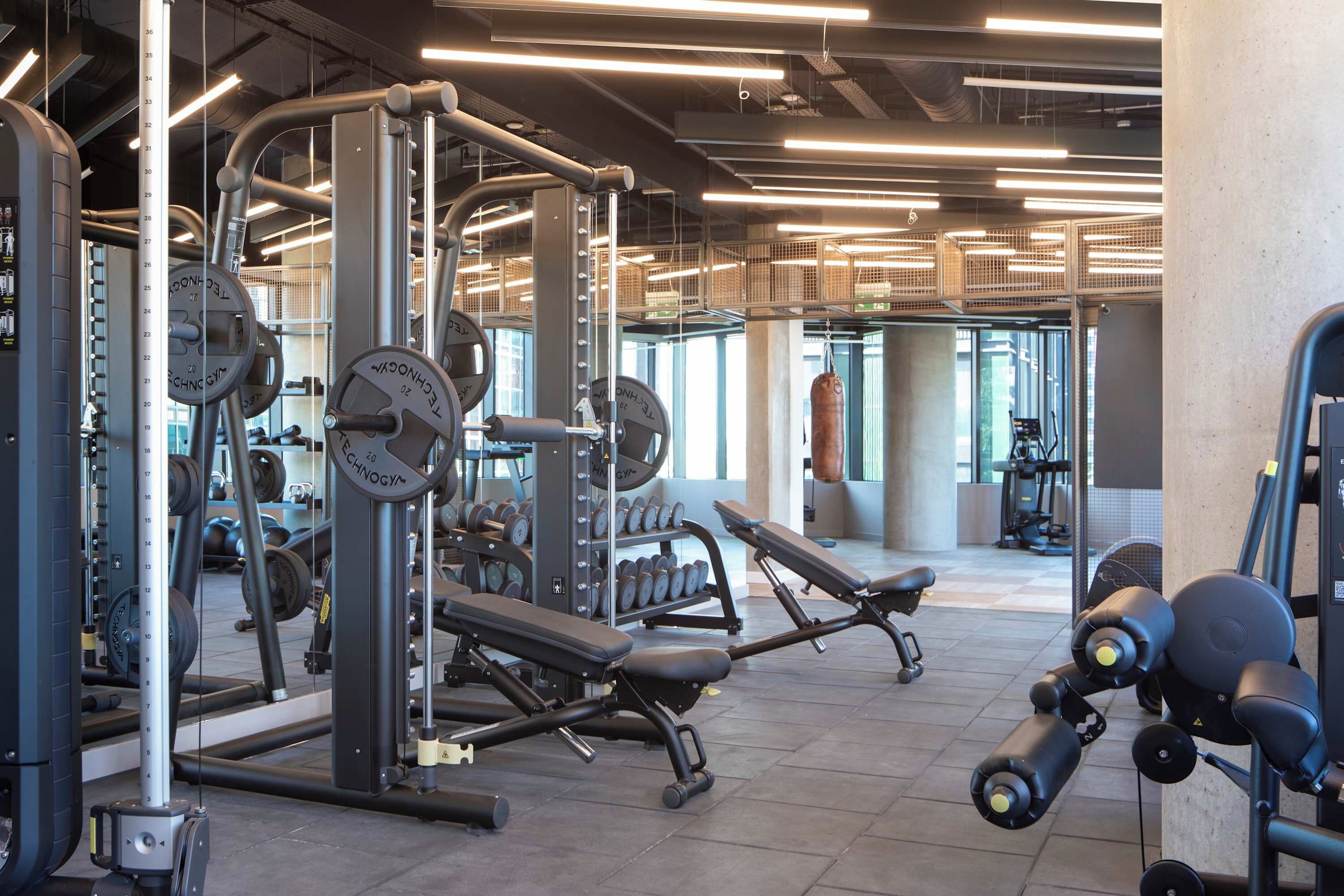 A gym with weightlifting equipment, benches, and dumbbells.