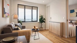 Een moderne woonkamer met een bank, een kleine ronde tafel en een groot raam.
