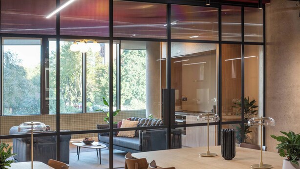 A modern interior with a dining area, sofas, and large windows offering a view of the outdoors. - Central Croydon Studio | 40+ Amenities | StayCozy (Croydon)
