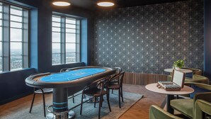 A pool table with chairs, a small table with a plant, and large windows with a city view. - Central Croydon Studio | 40+ Amenities | StayCozy (Croydon)