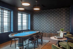 A pool table with chairs, a small table with a plant, and large windows with a city view. - Central Croydon Studio | 40+ Amenities | StayCozy (Croydon)