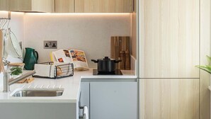 Een moderne keuken met houten kastjes, een wit aanrecht en een inbouwoven.
