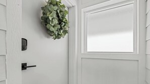 En hvid dør med et glasfelt og en ringeknap.