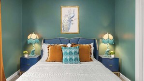 A bedroom with a bed, two nightstands, lamps, a framed picture, and decorative pillows. - The High Roller House | Hot Tub & Pool Table (Meridian)