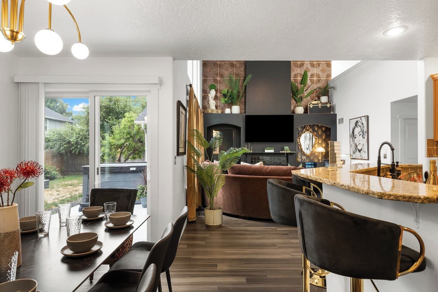 A modern kitchen with a dining area, a fireplace, and a TV.