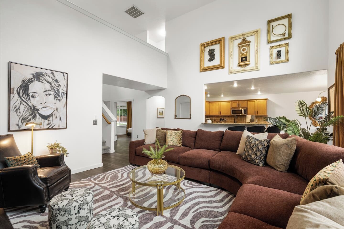 Uma sala de estar moderna com um sofá modular, uma mesa de centro redonda e um tapete estampado com padrão de zebra.