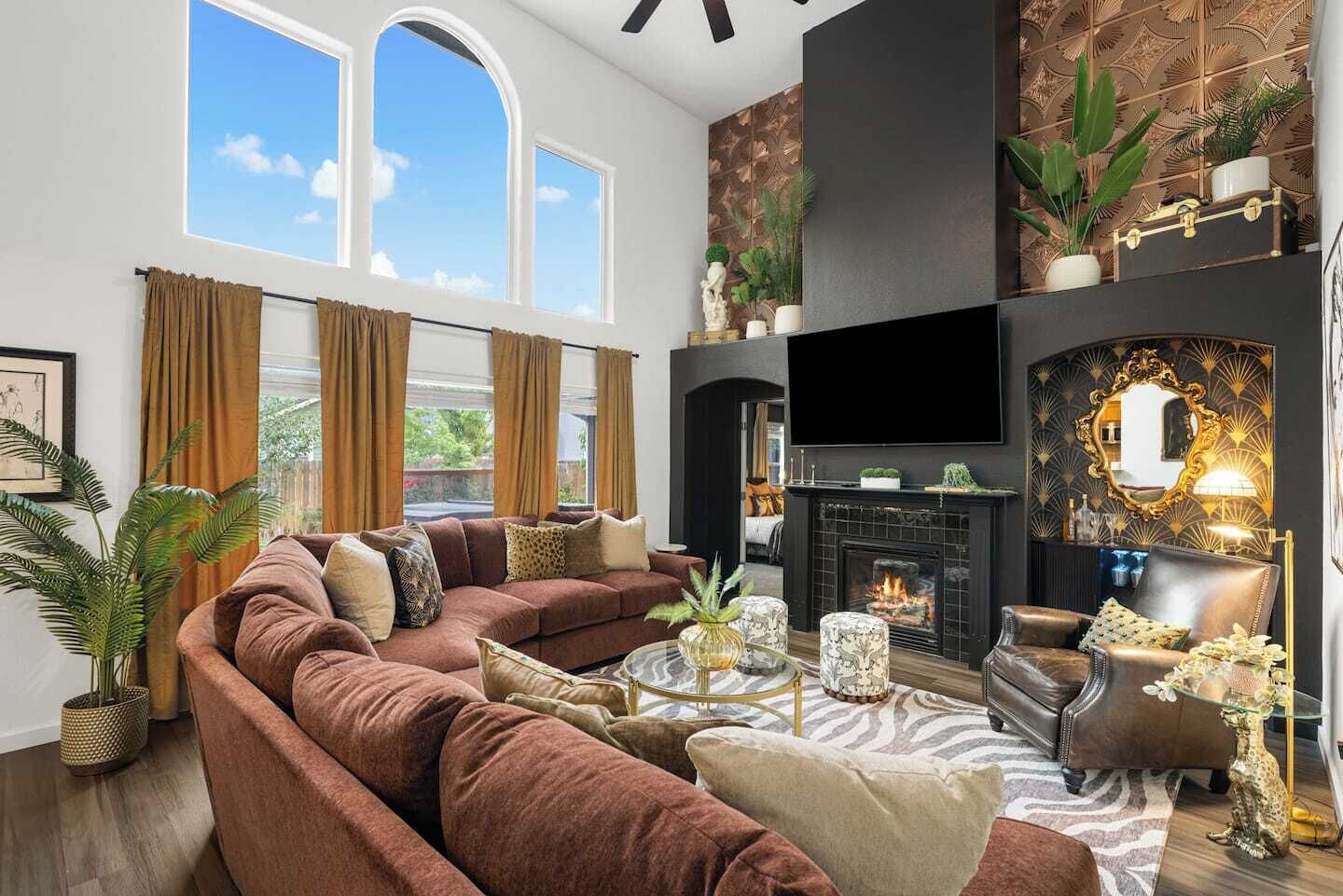 Ein Wohnzimmer mit einem braunen Sofa, einem Kamin und einem Fernseher.