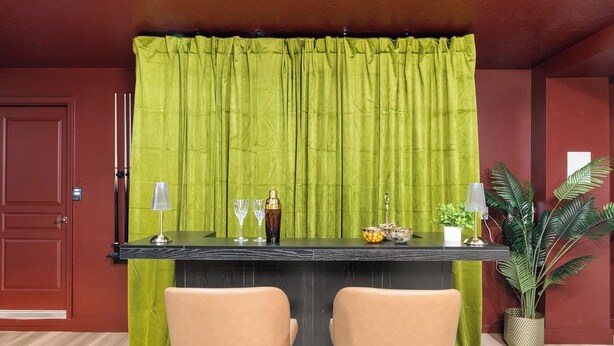 A bar area with a green curtain backdrop, two chairs, a bar counter, and a potted plant. - The High Roller House | Hot Tub & Pool Table (Meridian)