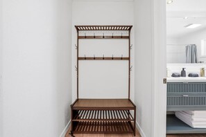Ein hölzerner Kleiderhaken mit Haken und Ablagefläche im Badezimmer.
