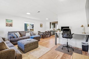 A modern living room with a sofa, ottoman, and dining area. - Boise's Walkable Gem-Office-Patio-Park (Boise)