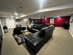 Uma sala de estar com um sofá seccional, uma mesa de centro e um tapete.