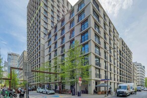 Ein mehrstöckiges Gebäude mit modernem architektonischen Design, gekennzeichnet durch eine Anordnung von Fenstern und Balkonen.