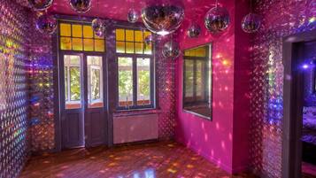 A room with wooden flooring, large windows, and disco balls.