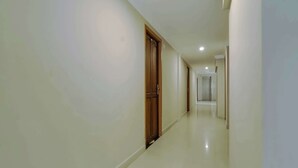 Un pasillo con una puerta de madera y una pared blanca.