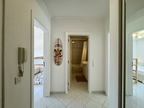 A hallway leading to a bathroom with a shower and a toilet. - Vilamoura Golf Apartment 3 by Homing (Loulé)