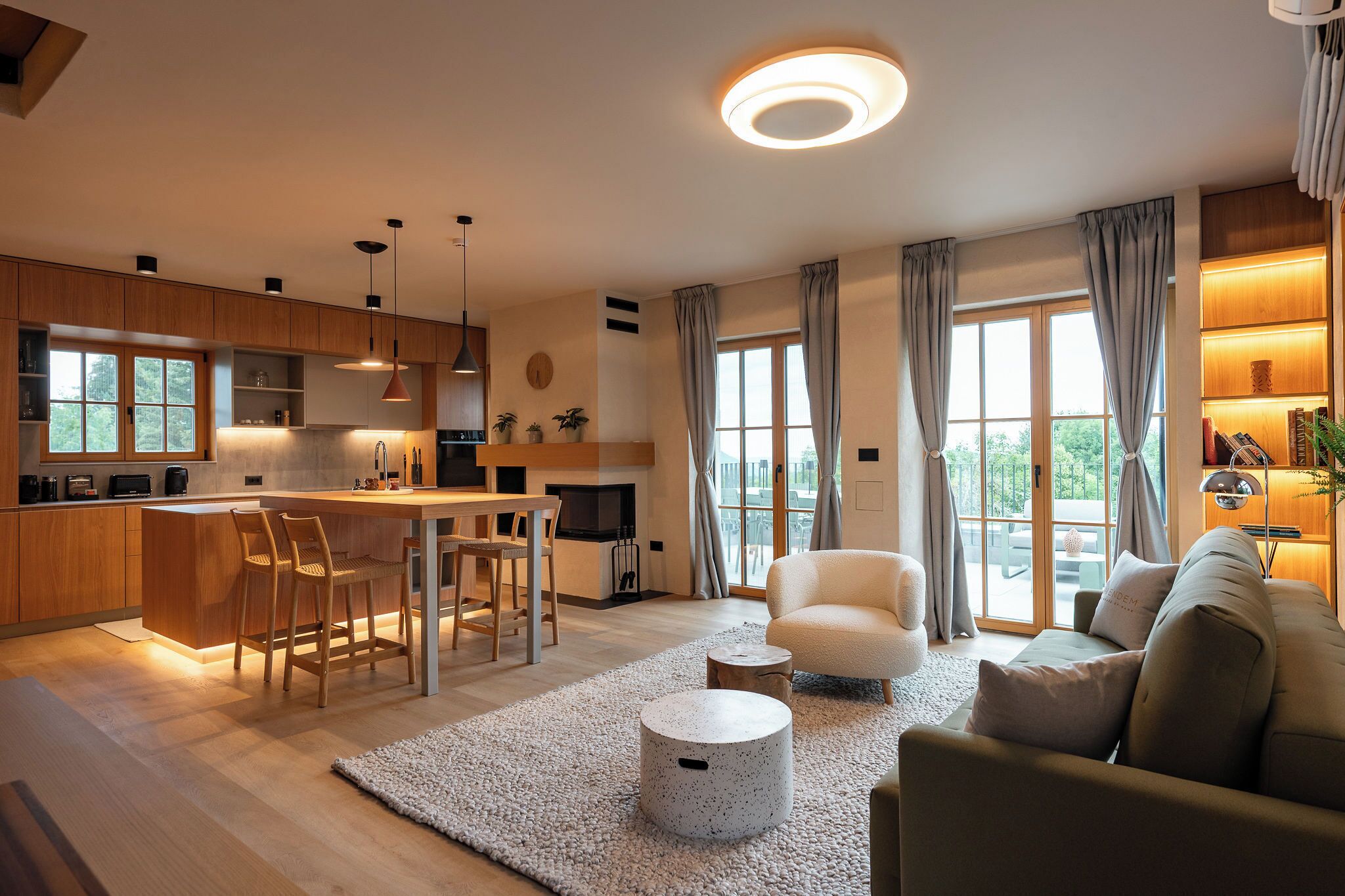 Un salon moderne comprenant un canapé, une table basse et un coin repas avec des chaises.
