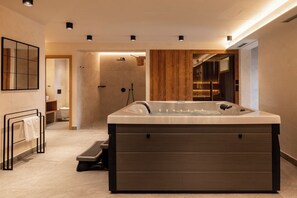 Een moderne badkamer met een vrijstaand ligbad, een houten wastafelmeubel en een spiegel.