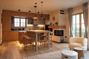 Eine moderne Küche mit Holzschränken, einer Mittelinsel und Pendelleuchten.
