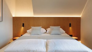 Ein Hotelzimmer mit einem großen Bett, zwei Nachttischen und einem hölzernen Kopfteil.