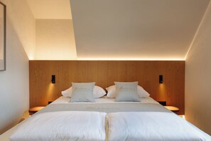 Ein Hotelzimmer mit einem großen Bett, zwei Nachttischen und einem hölzernen Kopfteil.