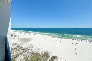 A beach with a clear view of the ocean, a sandy shore, and a few umbrellas. - Gulf front Bliss at The Palms 1015B - Orange Beach, AL - Signature Properties (Orange Beach)