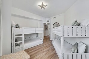 Ein Kinderzimmer mit Etagenbetten, einer gewobenen Bank und einer deckenhohen Sternleuchte.
