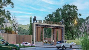 En moderne bygning med en markant skiltning, en løvestatue og en belagt indkørsel med parkerede biler.