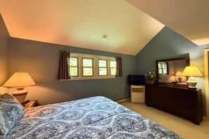 A bedroom with a bed, a dresser, a television, and a window with curtains. - Three Bedroom condo- 200 yard walk to ski slopes (Sugar Mountain)
