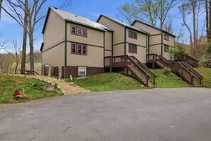 A two-story building with a front entrance, a driveway, and a staircase leading to the upper level. - Three Bedroom condo- 200 yard walk to ski slopes (Sugar Mountain)