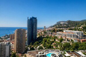 A coastal cityscape with modern high-rise buildings, a clear blue sky, and a view of the sea. - Near Monaco Top Floor Sea View Terrace (Beausoleil)