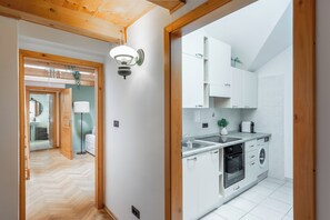 A modern kitchen with white cabinets, a sink, and a stove. - Luxury 2BR Apartment Steps from Old Town Square (Praha)