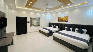 A hotel room with two beds, a flat-screen TV, a ceiling with recessed lighting, and a modern design. - HOTEL PANNA HAVELI (Amer)