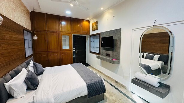 A bedroom with a bed, wooden wardrobe, TV, and a mirror. - HOTEL PANNA HAVELI (Amer)