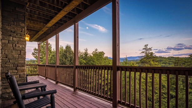 A wooden deck with a railing, benches, and a stone wall. - New Listing, Game Room, Theater Room, Free Attractions (Sevierville)