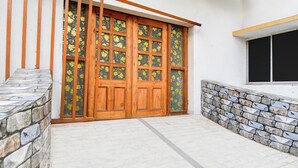 A wooden door with glass panels, a stone wall, and a window with black blinds. - Collection O Howrah Botanical Garden (Howrah)
