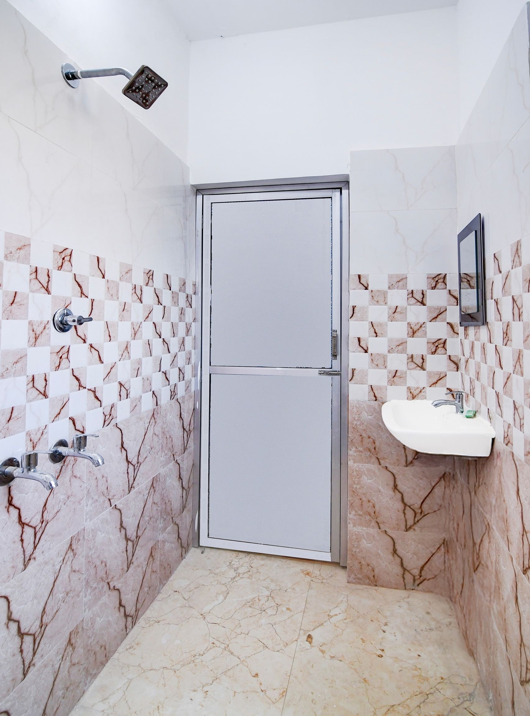 A bathroom with a shower, a sink, and a door.