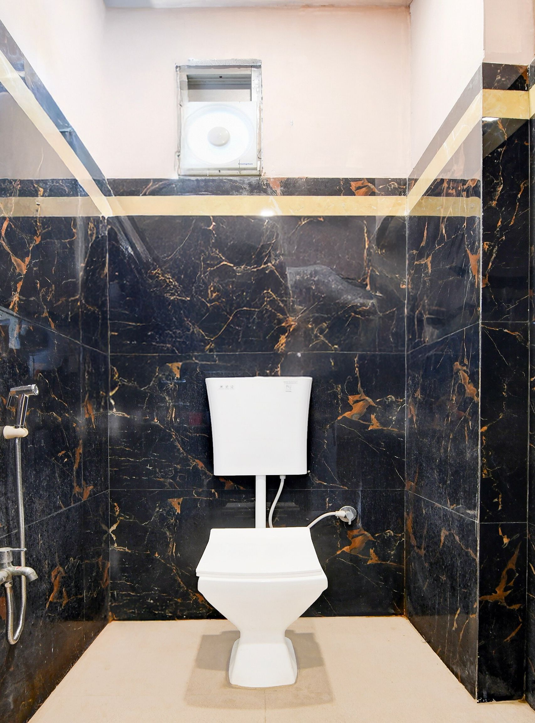 A bathroom with a toilet, a shower, and a small window.