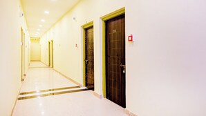 A hotel corridor with doors, a fire alarm, and a sign indicating room number 213. - Collection O Howrah Botanical Garden (Howrah)