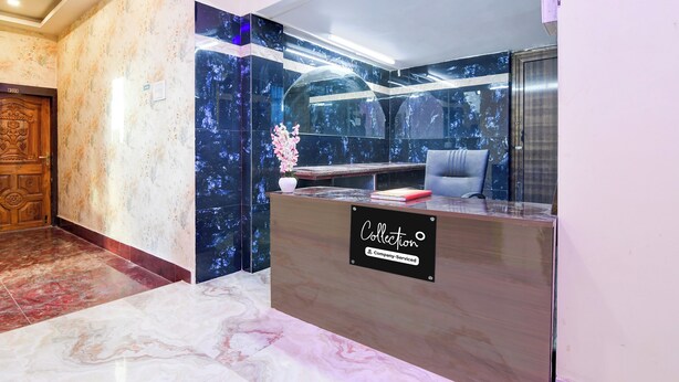 A reception desk with a 'Collection' sign, marble flooring, and a wooden door with a number plate. - Collection O Howrah Botanical Garden (Howrah)