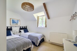 A bedroom with two beds, a window, a radiator, and a hanging light fixture. - The Old Coach House -  Ansty, Dorchester sleeps 4 guests  in 2 bedrooms (Ansty)