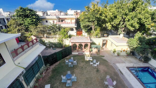 A courtyard with outdoor seating, a pool, and surrounding greenery. - Super Collection O Mall  (Jaipur)