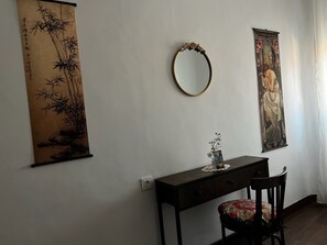 A room with a desk, chair, wall-mounted mirror, and two framed artworks. - Pensión El Palmar (Tobarra)
