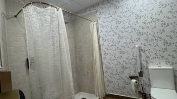Un baño con ducha, inodoro y lavamanos.