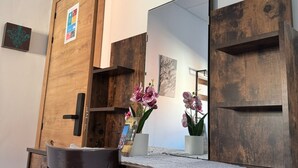 A wooden desk with a mirror, a chair, and a small orchid plant. - Pensión El Palmar  (Tobarra)